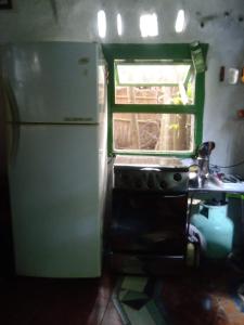 a kitchen with a refrigerator and a sink and a window at Casa Marindia una cuadra playa in Salinas 