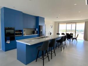 a kitchen with blue walls and a counter with bar stools at Koopalanda Dreaming in Vivonne Bay