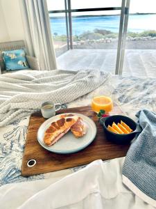 a breakfast tray with a plate of food on a bed at Koopalanda Dreaming in Vivonne Bay