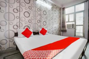 um quarto com uma cama grande e almofadas vermelhas em OYO Flagship Corporate House em Gurgaon