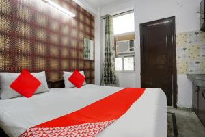 1 dormitorio con 1 cama grande con almohadas rojas en OYO Flagship Corporate House en Gurgaon