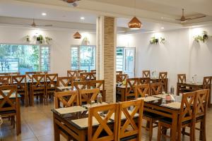 a dining room with wooden tables and chairs at Munnar Ice Queen Resorts in Munnar