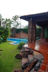 a patio with a stone wall next to a swimming pool at Villa Adela in Luque