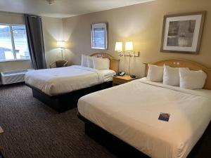 a hotel room with two beds and a window at Baymont by Wyndham Lawrenceburg in Lawrenceburg