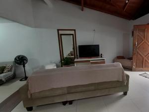 a bedroom with a bed and a flat screen tv at Casa de Temporada Praia do Moçambique in Florianópolis