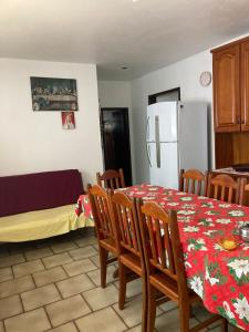 eine Küche mit Tisch und Stühlen und einem Kühlschrank in der Unterkunft Casa na Praia, Torres RS in Torres