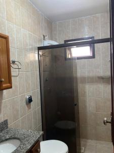 a bathroom with a shower with a toilet and a sink at Casa na Praia, Torres RS in Torres