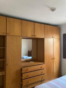 ein Schlafzimmer mit Holzschränken und einem Bett in der Unterkunft Casa na Praia, Torres RS in Torres
