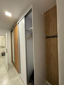 um quarto com um armário com uma porta de vidro deslizante em Apartament ZłotogórSKI Lądek-Zdrój em Lądek-Zdrój