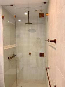 een douche met een glazen deur in de badkamer bij Galleria Deluxe & Spacious apartment + Shopping Centre & Train in Glen Waverley