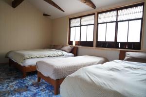 a room with two beds and two windows at 桜香楽　宮津町家　Sakara Miyazu-Machiya in Miyazu
