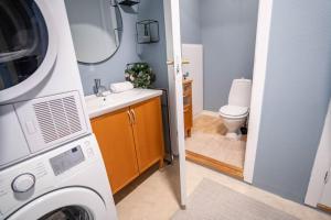 uma casa de banho com uma máquina de lavar roupa, um lavatório e um WC. em The Green House of Stavanger BnB 14 -Central, Sauna and Airport Shuttle em Stavanger