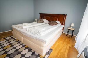 a bedroom with a large bed with white sheets at The Green House of Stavanger BnB 14 -Central, Sauna and Airport Shuttle in Stavanger