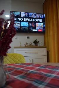um quarto com uma televisão na parede e uma cama em Apartament ZłotogórSKI Lądek-Zdrój em Lądek-Zdrój
