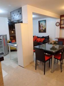 a kitchen and a dining room with a table and chairs at EDIFICIO MARIA KIAN in San Bartolo