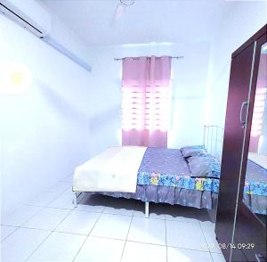 um quarto com uma cama e uma janela em HOMESTAY NAFISAH em Tapah Road
