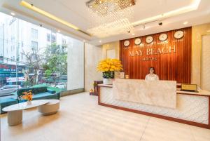 uma mulher parada no lobby de um hotel pode quebrar em May Beach Hotel em Da Nang