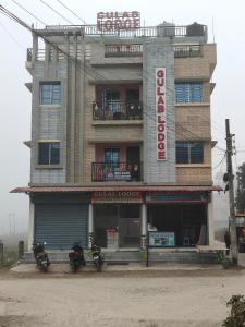 a building with two motorcycles parked in front of it at GULAB LODGE in Siliguri