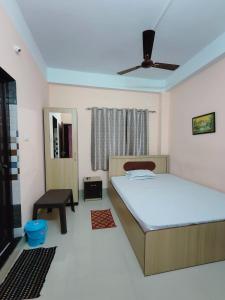 a bedroom with a bed and a ceiling fan at GULAB LODGE in Siliguri