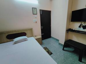a hotel room with a bed and a television at GULAB LODGE in Siliguri