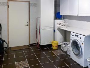 eine Küche mit einer Waschmaschine und einem Kühlschrank in der Unterkunft Holiday home Vikholmen 