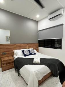 een slaapkamer met een groot bed en een raam bij Traveller's stay for 10 pax in Ipoh +55 foto's