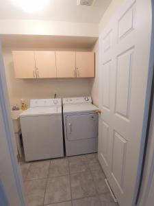 a white laundry room with a washer and dryer at Rooms near Train Station in Burlington
