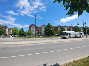 a white bus driving down a city street at Rooms near Train Station in Burlington