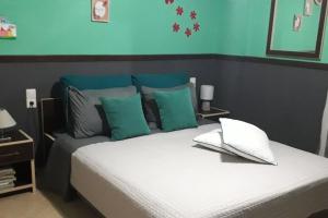 una camera da letto con un letto con cuscini verdi e blu di Amazing Beachside Apartment With Panoramic Seaview a Paránimfoi