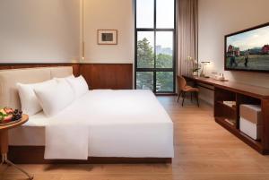 Posteľ alebo postele v izbe v ubytovaní Wuyu Hotel, Smart Park & Happy Valley Jinshansi Metro