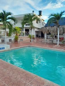 uma piscina em frente a uma casa com palmeiras em VILLA MARIA em Turbaco
