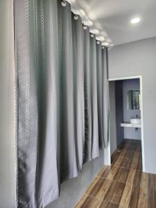 un pasillo con cortinas verdes y blancas en una habitación en No 9 HOUSE Hua Hin, en Khao Tao
