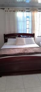 VILLA MARIA في Turbaco: سرير كبير في غرفة نوم مع نافذة
