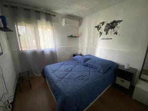 um quarto com uma cama azul e um mapa na parede em Lindo apto Mvd shopping puerto de buceo/pocitos em Montevidéu