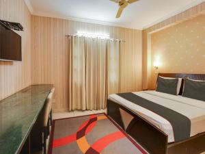 a hotel room with a bed and a television at Super Collection O KOP INTERNATIONAL in Ludhiana