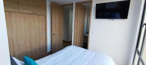 a bedroom with a bed and a tv on a wall at Apartamento para descansar 3 in Paipa