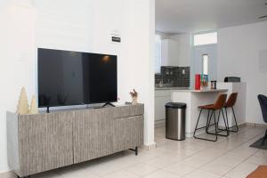 ein Wohnzimmer mit einem Flachbild-TV auf einem Schrank in der Unterkunft Islabella Guest House in Isabela