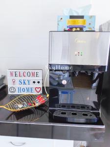 a counter with a coffee maker and a sign at SkyHome @ D'Perdana Kota Bharu in Kota Bharu