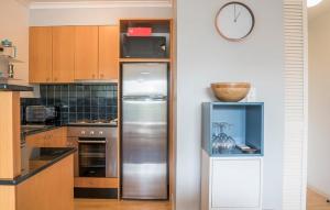 a kitchen with a refrigerator and a clock on the wall at Entire Apartment in Surry Hills in Sydney