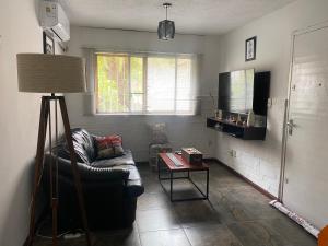 a living room with a leather couch and a table at Lindo apto Mvd shopping puerto de buceo/pocitos in Montevideo