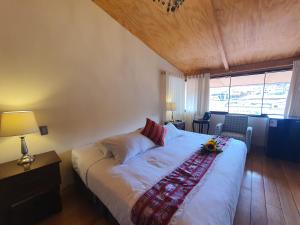 Un dormitorio con una gran cama blanca y una ventana en Cusco Hotel Boutique, en Cusco