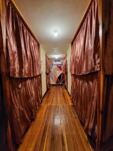 a long hallway with wooden floors and curtains at Dam Dam Place in San Vicente