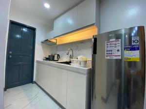 een keuken met een zwarte deur en een koelkast bij Casa Amelita Malolos 