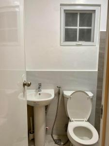 een badkamer met een toilet, een wastafel en een raam bij Casa Amelita Malolos 