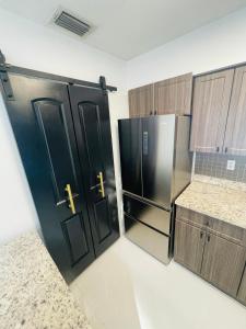 a kitchen with two black doors and a refrigerator at Cozy Comfy House in Pembroke Pines