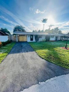 a house with a driveway in front of a yard at Cozy Comfy House in Pembroke Pines