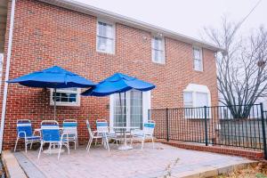 un patio con sillas y sombrillas frente a un edificio de ladrillo en Sheppard, en Washington