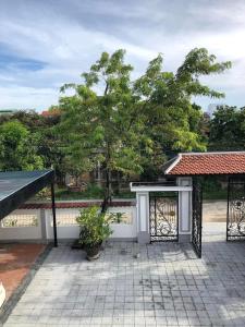 a patio with a gate and a tree at Nhat Long Homestay in Hue
