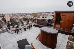 a rooftop patio with a grill and tables and chairs at Albelli Luxury Skyview in Košice +78 photos