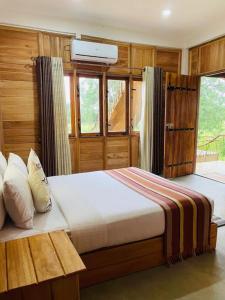 una camera con un grande letto e una finestra di Prana Ayurveda Chalet- Sigiriya a Sigiriya